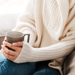 woman sitting on sofa with coffee cup