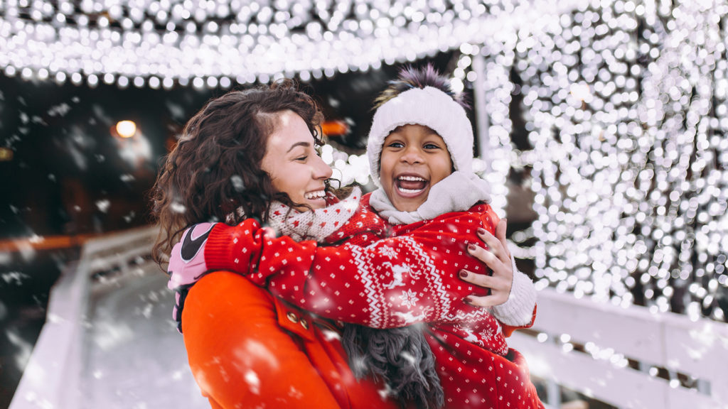 Little girl enjoying in ice skating with her mother.